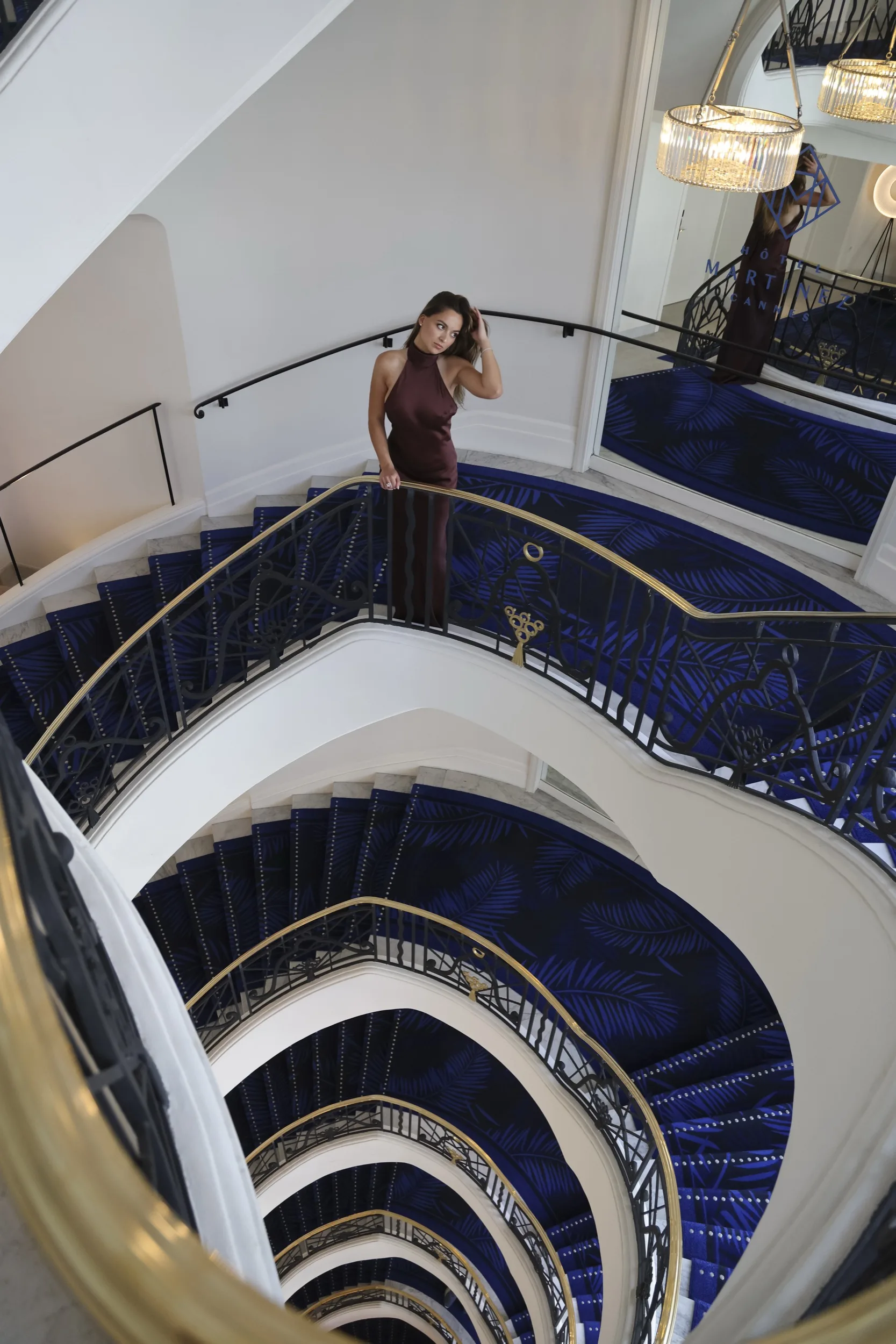Burgundy gown — Martinez spiral staircase, Cannes 2026